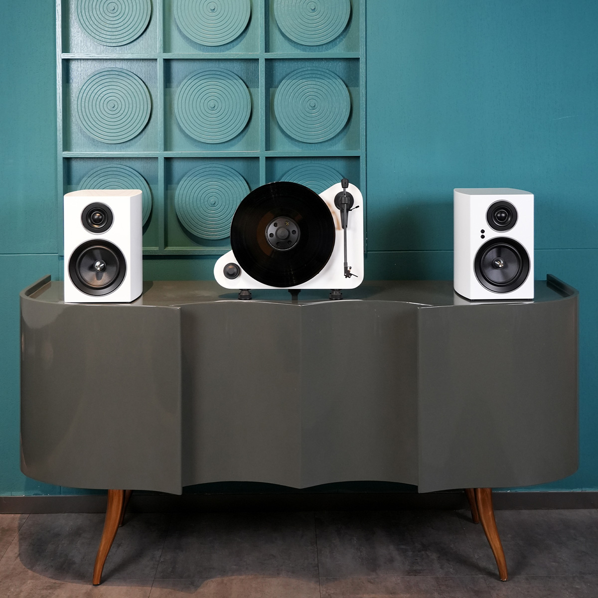 Jamo C707 Pa Active Bookshelf Speaker White bookshelf speakers with vinyl turntable on modern console.