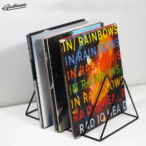 Black metal wire vinyl record rack holding multiple LPs, with Radiohead's In Rainbows album cover visibly front and center.