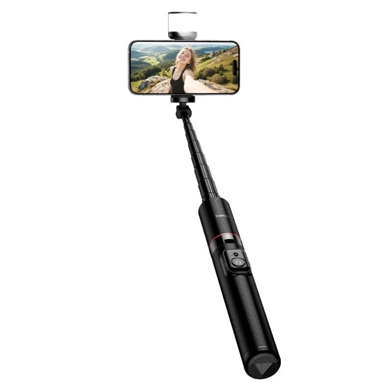 Hoco. K34 All-In-One Live Broadcast Holder A hoco. K34 all-in-one live broadcast holder in black securely holds a smartphone displaying a photo of a woman outdoors with mountains in the background, featuring an attached detachable remote control.