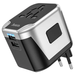The HOCO. AC5 Dual USB Universal Charger Adapter is a black and silver universal travel adapter featuring dual USB ports and interchangeable plug options.