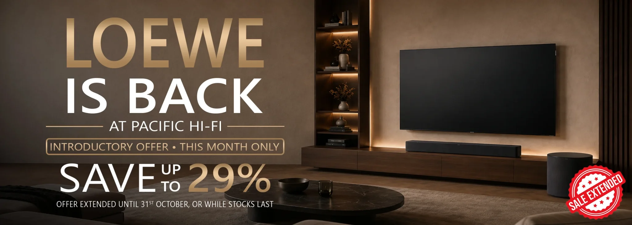 Loewe television mounted on a wall in a modern living room with a wooden media unit and warm shelving lighting