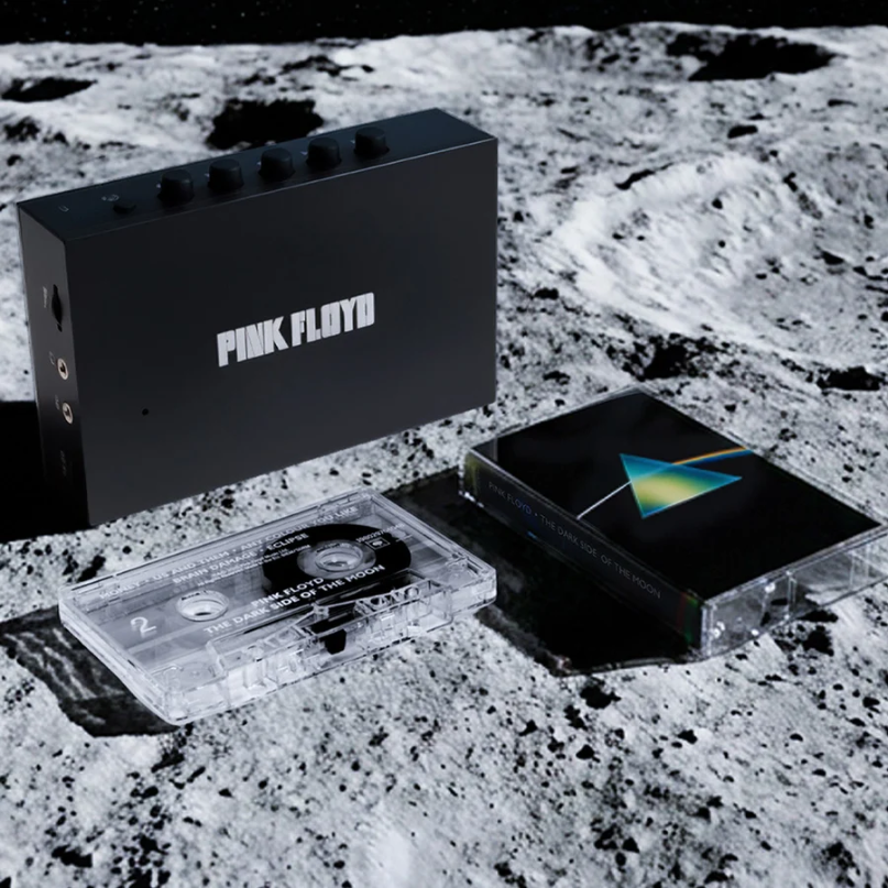 We Are Rewind Limited Edition Pink Floyd Portable Cassette Player &Amp; Recorder Pink floyd-branded black audio device with five knobs on top, beside dark side of the moon cassette.