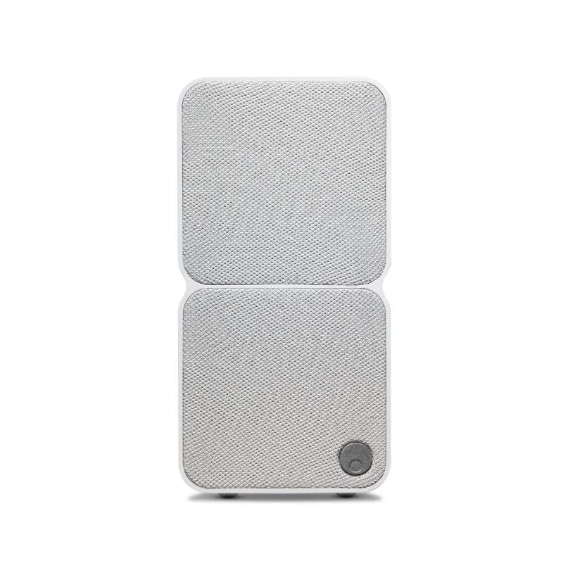Two-panel fabric-covered portable speaker with rounded corners and a circular control button at the bottom-right